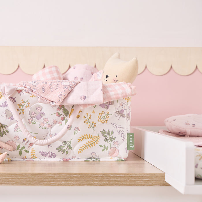 Close-up of the Tiny Tails nappy caddy in pink floral woodland print, styled on a nursery shelf with soft toys and muslin cloths
