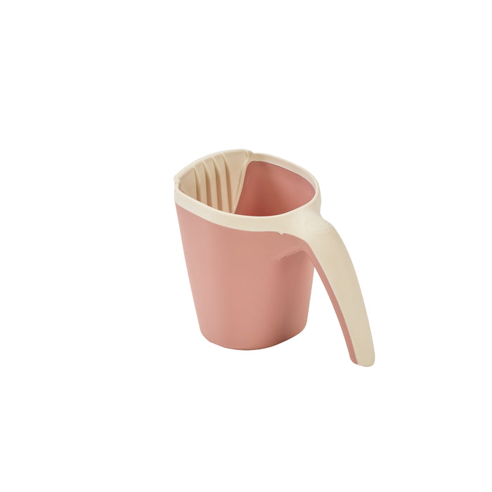 Rear angled view of the Nati Baby Bath Jug in shell highlighting compact shape, curved handle and softly rounded design.