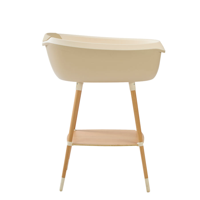 Side view of Nati Baby Bath in dune on wooden stand, in a white background.
