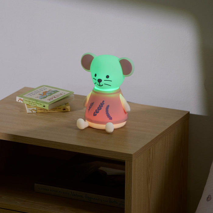 Children's night light shaped like a mouse on a wooden nightstand with a book in the background.