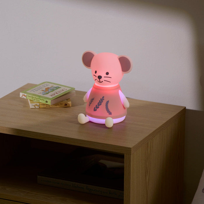 Pink mouse-shaped night light on a wooden nightstand with a book in the background.