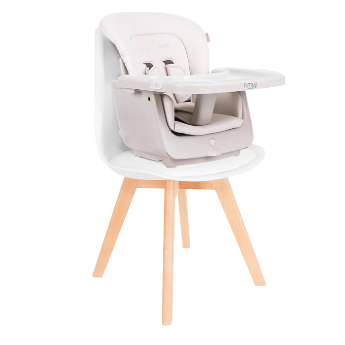 Nova Evolutionary Highchair in Scandinavian Walnut and Ecru shown in booster seat mode secured to a dining chair, demonstrating its space-saving and travel-friendly functionality