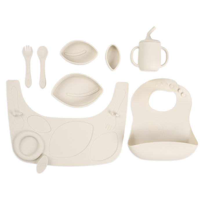Flat lay of the Nova Maison highchair accessory pack in rusk, including silicone bib, plates, bowl, cutlery and training cup.