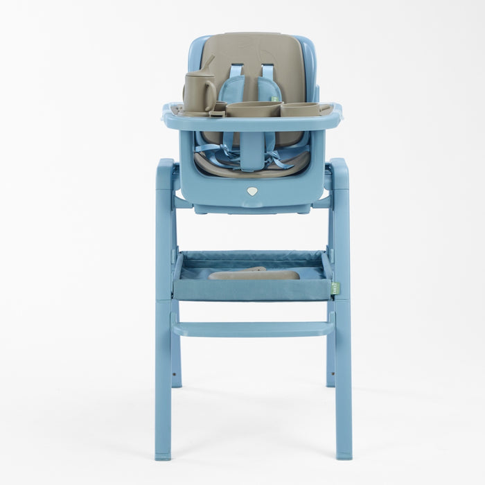 Front cutout view of the Nova highchair styled with the cocoa accessory pack, featuring divided bowls, cup, bib and integrated tray layout.