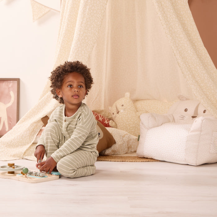 Child playing with toys in a cosy room with the Love Cat canopy and bean chair.