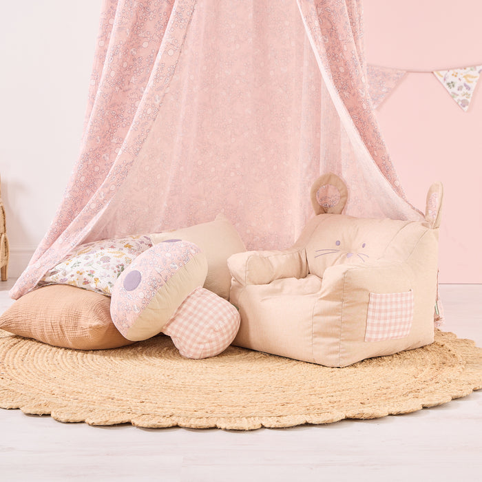 Children's room with pink canopy, plush toys, and a textured rug on a light wooden floor.