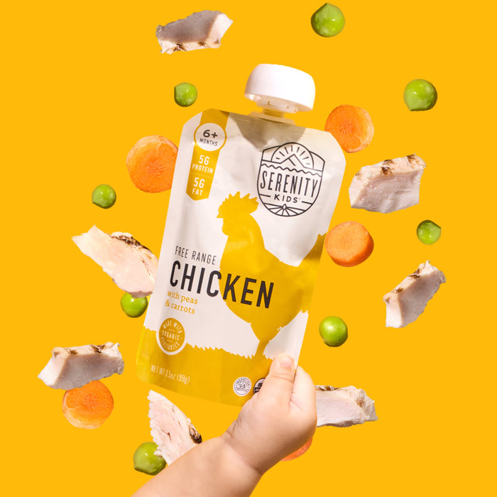 Serenity Kids chicken pouch held by a hand with vegetables on a yellow background