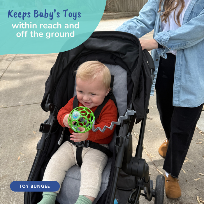 baby in stroller playing with ball attached to stroller handle with busy baby pewter toy bungee