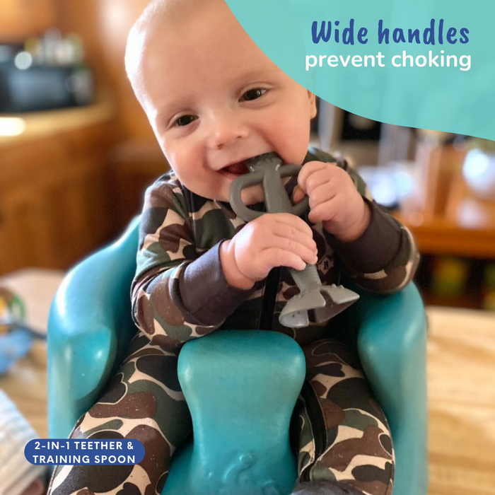 baby in sit up seat chewing on busy baby 2-in-1 teether and training spoon
