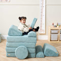 Toddler sitting and smiling while playing with cushions on the Playrama Montessori Kids Play Sofa in ocean stone, styled as a stacked seat