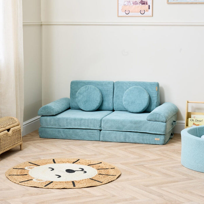 Lifestyle view of the Playrama Montessori Kids Play Sofa in ocean stone, styled with round cushions and set in a modern playroom