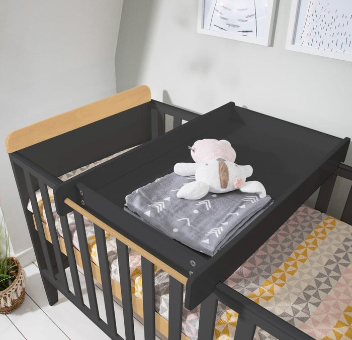 Close-up of the Rio cot bed cot top changer in slate grey and oak, showing smooth changing surface and secure fit above the cot