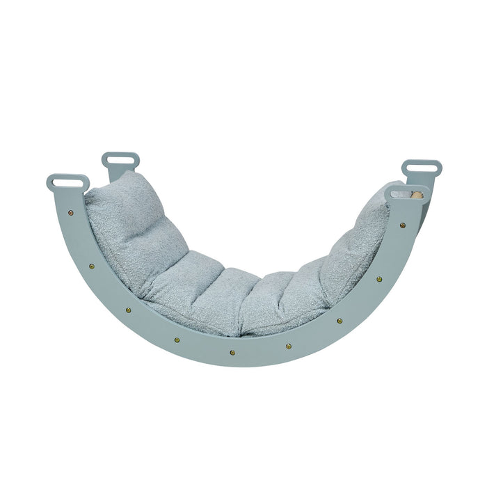 Side view of the scala montessori pikler cushion in boucle ocean stone, highlighting the soft textured padding shaped to fit the rocking frame.