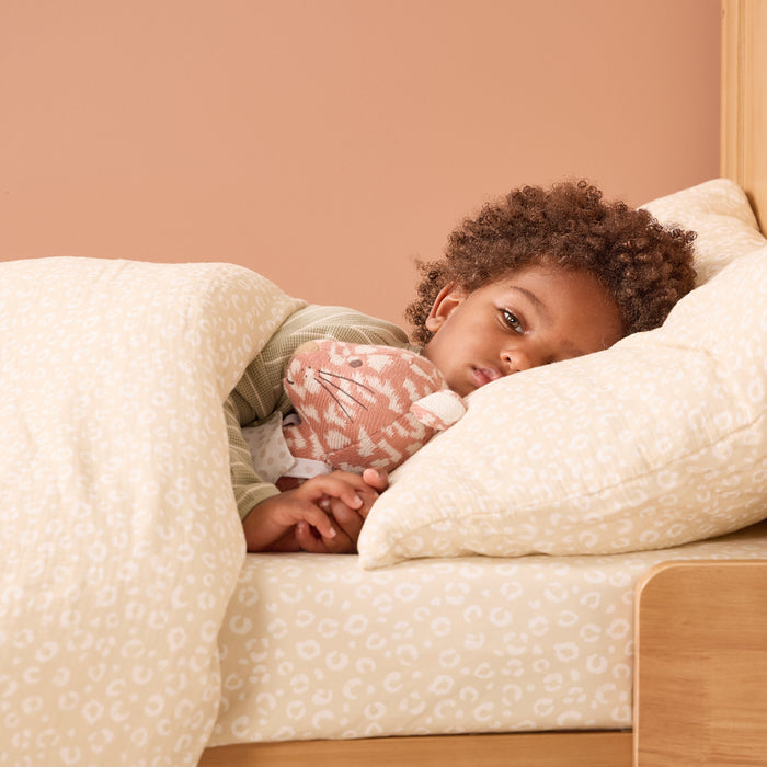 Toddler resting under love cats duvet cover and pillowcase set, creating a calm and comforting bedtime atmosphere.
