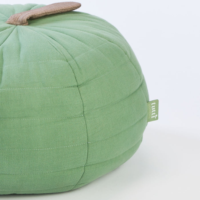 Side profile of the Soft Muslin Apple Cushion showcasing its rounded silhouette, stitched quilting and subtle neutral stem detail