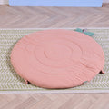 Soft Muslin Padded Playmat in apple shown on woven rug, featuring cushioned circular design and leaf accents.