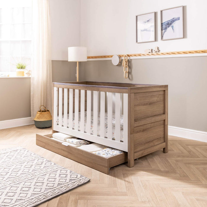 Modena cot bed with underbed storage drawer opened in a nursery setting
