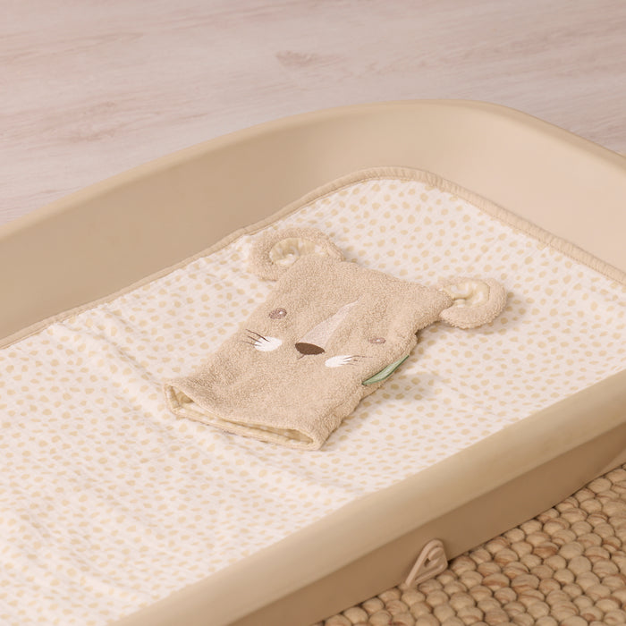 Wash mitt with a leopard design on a changing table with a neutral background
