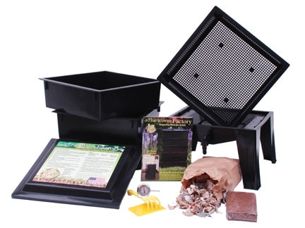 A black Worm Factory 365 Vermicomposting System with a box of seeds and a box of compost by Natures Footprint.