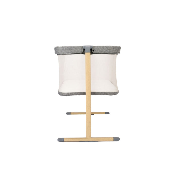 Baby crib with grey top, mesh panel and wooden legs on a white background